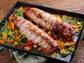 Pieczone polędwiczki wieprzowe w boczku, podane z pieczonymi warzywami i rozmarynem. Pyszna okrasa na obiad.