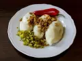 Trzy ziemniaczane kartacze z okrasą, posypane skwarkami, podane z ogórkiem kiszonym i papryczką chili.