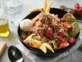 Sałatka z tuńczykiem, pomidorami i ogórkiem, inspirowana dieta śródziemnomorska przepisy. Z oliwą i pieczywem.