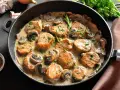 Soczysty schab w sosie pieczarkowym, udekorowany natką pietruszki, podany w żeliwnej patelni. Aromatyczne danie, które zachwyca smakiem.