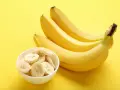 Kilka żółtych bananów i miseczka pokrojonych plasterków. Poznaj banan wartości odżywcze i ciesz się zdrową przekąską!