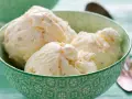 Puszyste lody z mascarpone, pełne delikatnych kawałków, kuszą kremową konsystencją w zielonej miseczce.