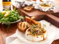 Pyszny camembert z grilla, polany miodem i posypany pistacjami, podany z grzankami i sałatką. Idealny na letnie wieczory.