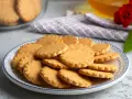 Stos szybkich kruchych ciasteczek na talerzu z niebieskim wzorem. Idealne na popołudniową herbatkę.