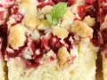 Wilgotne ciasto drożdżowe z truskawkami, posypane kruszonką i ozdobione listkiem mięty. Idealne na letnie popołudnie.