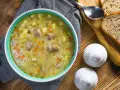 Aromaticzny zupa krupnik przepis babci, pełna ziemniaków, marchewki i mięsa, podana z chlebem.