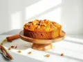 Pyszne ciasto bez cukru, ozdobione pomarańczą i orzechami, prezentuje się apetycznie na drewnianym paterze. Obok leży marchewka.