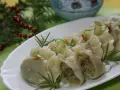 Pyszne pierogi ukraińskie, udekorowane szczypiorkiem i rozmarynem, na świątecznym stole.