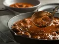 Gęsty, aromatyczny gulasz wołowy w żeliwnej patelni, gotowy do podania. Idealny przykład, jak zagęścić gulasz, by był sycący i pyszny.