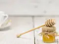 Mały słoiczek miodu z drewnianą chochlą, idealny do herbaty. Warto pamiętać o jego miód kcal.