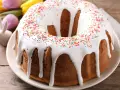Babka z lukrem i kolorową posypką, ozdobiona wielkanocnymi zajączkami i pisankami, gotowa na święta.