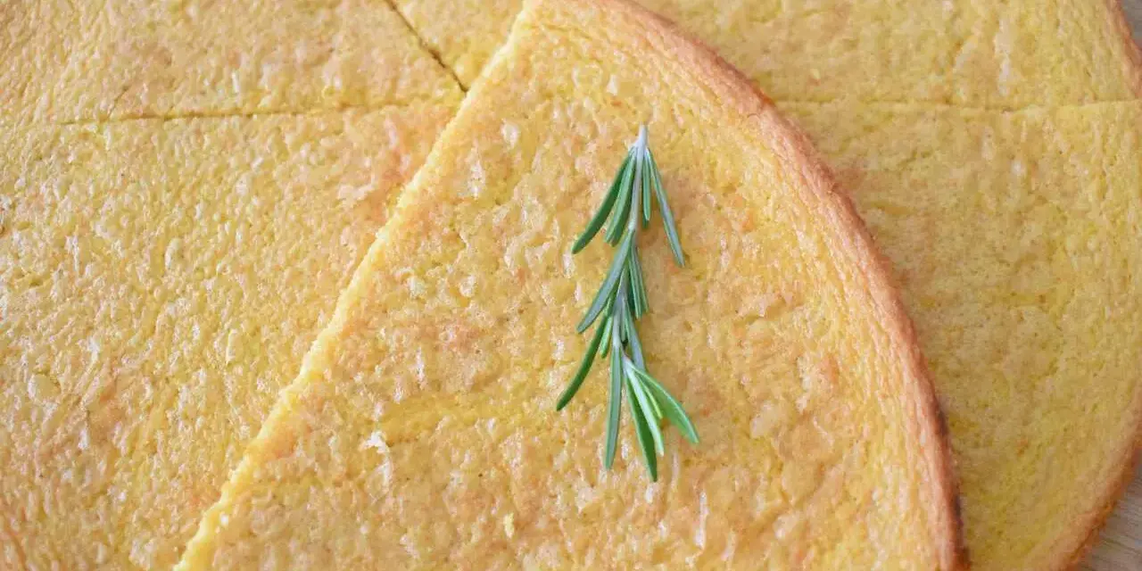 Schiacciata pokrojona w trójkąty, ozdobiona gałązką rozmarynu.