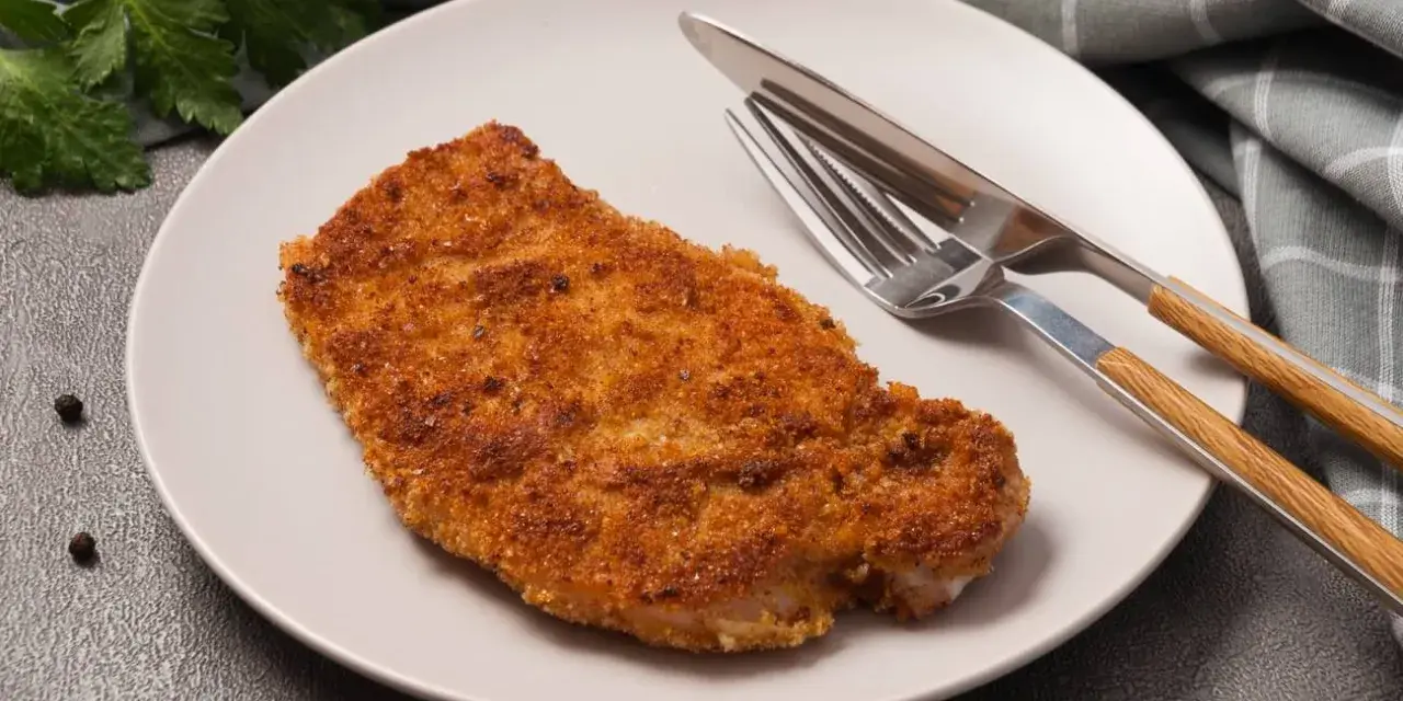 Złocisty kotlet schabowy na talerzu, gotowy do spożycia. Zastanawiasz się nad kotlet schabowy kcal?
