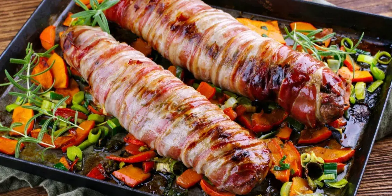 Pieczone polędwiczki wieprzowe w boczku, podane z pieczonymi warzywami i rozmarynem. Pyszna okrasa na obiad.