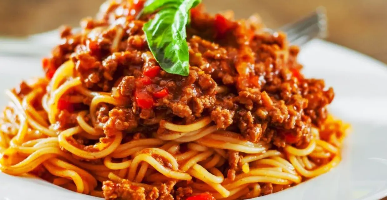 Pyszne spaghetti bolognese, idealne na prosty obiad. Aromatyczny sos mięsny z pomidorami i bazylią na złocistym makaronie.
