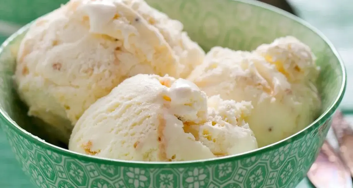Puszyste lody z mascarpone, pełne delikatnych kawałków, kuszą kremową konsystencją w zielonej miseczce.