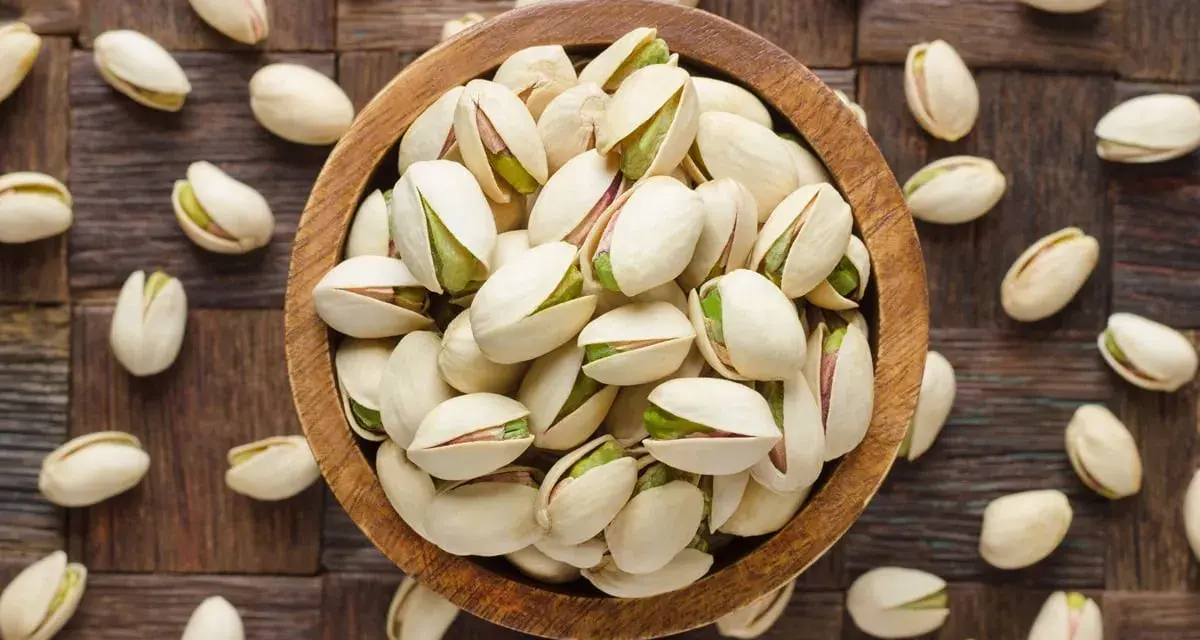 Miseczka pełna pistacji, które są świetną przekąską. Warto sprawdzić ich pistacje kcal przed spożyciem.