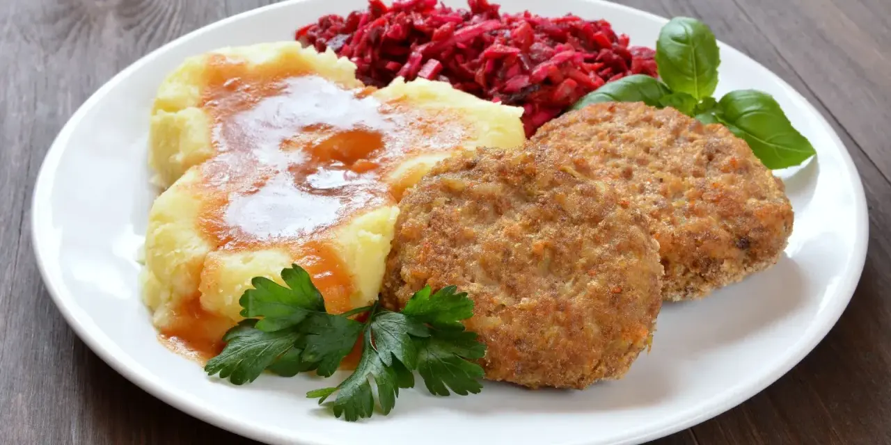 Pyszne mielone z piekarnika, podane z purée ziemniaczanym, buraczkami i natką pietruszki.