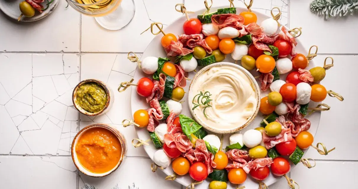 Kolorowe szaszłyki z pomidorkami, mozzarellą, salami i oliwkami – idealne finger food na imprezę.