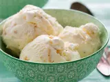 Puszyste lody z mascarpone, pełne delikatnych kawałków, kuszą kremową konsystencją w zielonej miseczce.