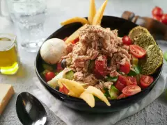 Sałatka z tuńczykiem, pomidorami i ogórkiem, inspirowana dieta śródziemnomorska przepisy. Z oliwą i pieczywem.