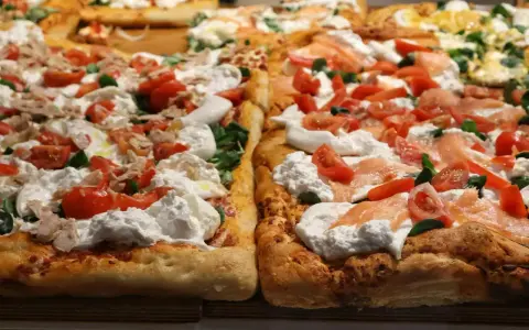 Pyszna pizza domowa na blachę z burratą, pomidorkami i łososiem. Idealny przepis na szybki obiad.