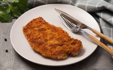 Złocisty kotlet schabowy na talerzu, gotowy do spożycia. Zastanawiasz się nad kotlet schabowy kcal?