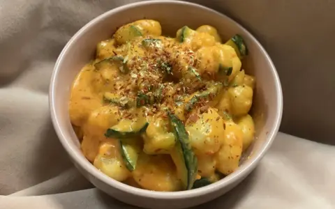 Puszyste gnocchi z cukinią w kremowym sosie, posypane ziołami i płatkami chili. Pyszne gnocchi z pesto w nowej odsłonie.