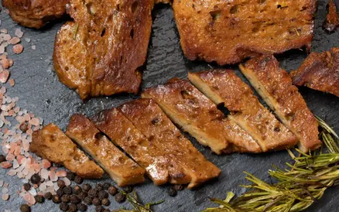 Pokrojony seitan, przypominający mięso, z rozmarynem i solą. To świetna alternatywa dla mięsa, jeśli zastanawiasz się, seitan co to.