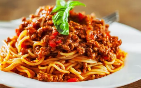 Pyszne spaghetti bolognese, idealne na prosty obiad. Aromatyczny sos mięsny z pomidorami i bazylią na złocistym makaronie.
