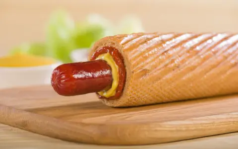 Pyszny hot dog francuski z musztardą i ketchupem, gotowy do zjedzenia.