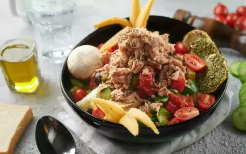 Sałatka z tuńczykiem, pomidorami i ogórkiem, inspirowana dieta śródziemnomorska przepisy. Z oliwą i pieczywem.