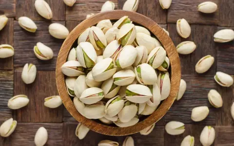 Miseczka pełna pistacji, które są świetną przekąską. Warto sprawdzić ich pistacje kcal przed spożyciem.