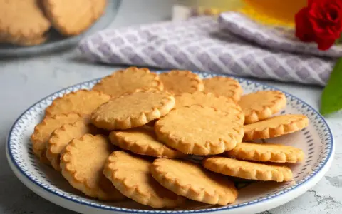 Stos szybkich kruchych ciasteczek na talerzu z niebieskim wzorem. Idealne na popołudniową herbatkę.