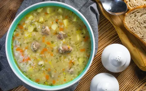 Aromaticzny zupa krupnik przepis babci, pełna ziemniaków, marchewki i mięsa, podana z chlebem.