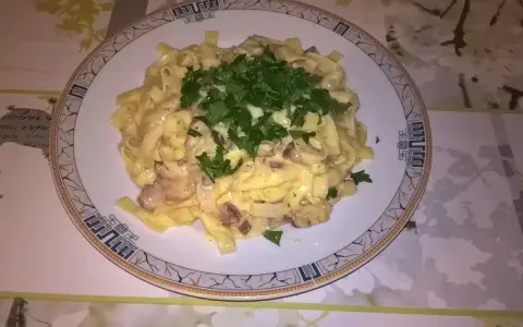 Pyszne fettuccine z boczkiem i pieczarkami, polane kremowym sosem. Idealna odpowiedź na pytanie: jaka śmietana do carbonary?