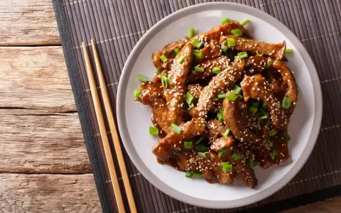 Pyszne mięso w sosie teriyaki, posypane sezamem i szczypiorkiem. Idealne do przygotowania w domu, oto prosty sos teriyaki przepis.