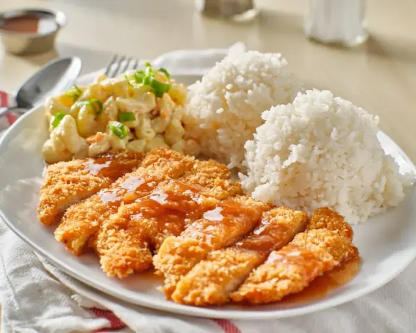 Chrupiący kurczak w panko polany sosem, podany z ryżem i sałatką makaronową. Pyszny obiad gotowy!