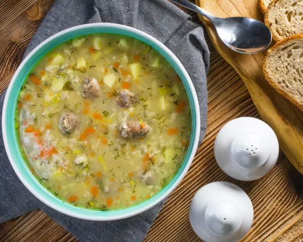 Aromaticzny zupa krupnik przepis babci, pełna ziemniaków, marchewki i mięsa, podana z chlebem.