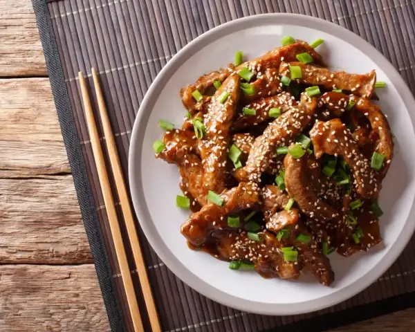 Pyszne mięso w sosie teriyaki, posypane sezamem i szczypiorkiem. Idealne do przygotowania w domu, oto prosty sos teriyaki przepis.