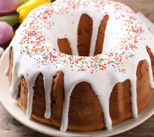 Babka z lukrem i kolorową posypką, ozdobiona wielkanocnymi zajączkami i pisankami, gotowa na święta.