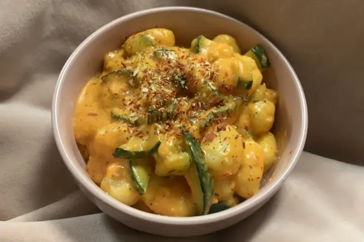 Puszyste gnocchi z cukinią w kremowym sosie, posypane ziołami i płatkami chili. Pyszne gnocchi z pesto w nowej odsłonie.