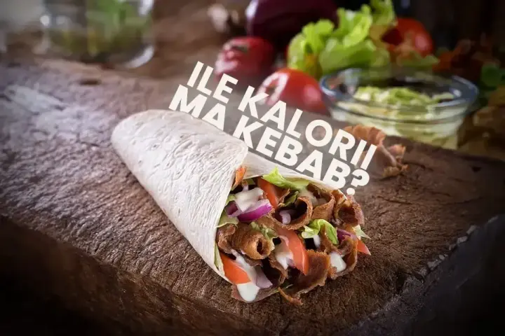 Pyszny kebab z mięsem, warzywami i sosem na desce. Ile kalorii ma kebab?