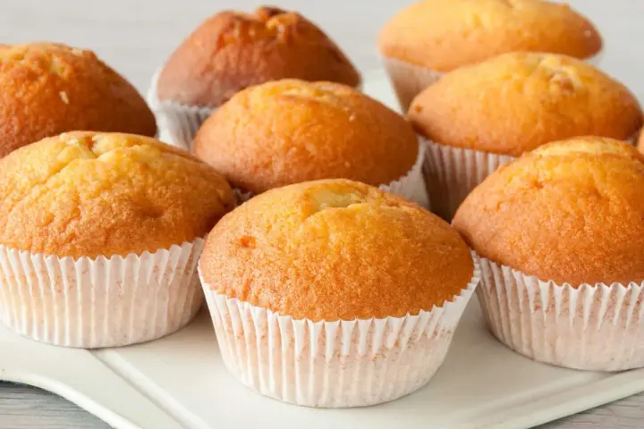 Złociste muffinki w papierowych foremkach, gotowe do podania. Idealne na uniwersalny przepis na muffinki, który sprawdzi się zawsze.