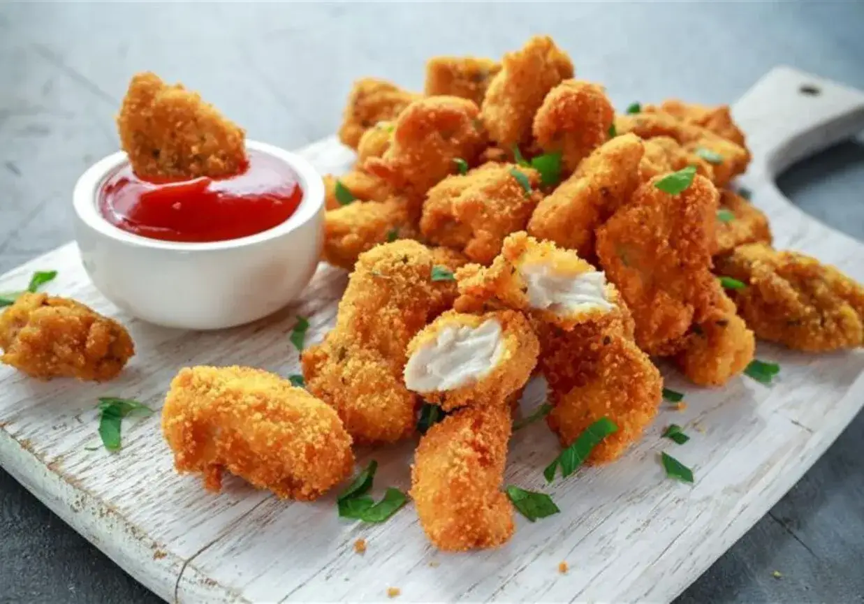 Chrupiące nuggetsy z airfryer, idealne do maczania w keczupie. Pyszna przekąska gotowa w kilka minut.