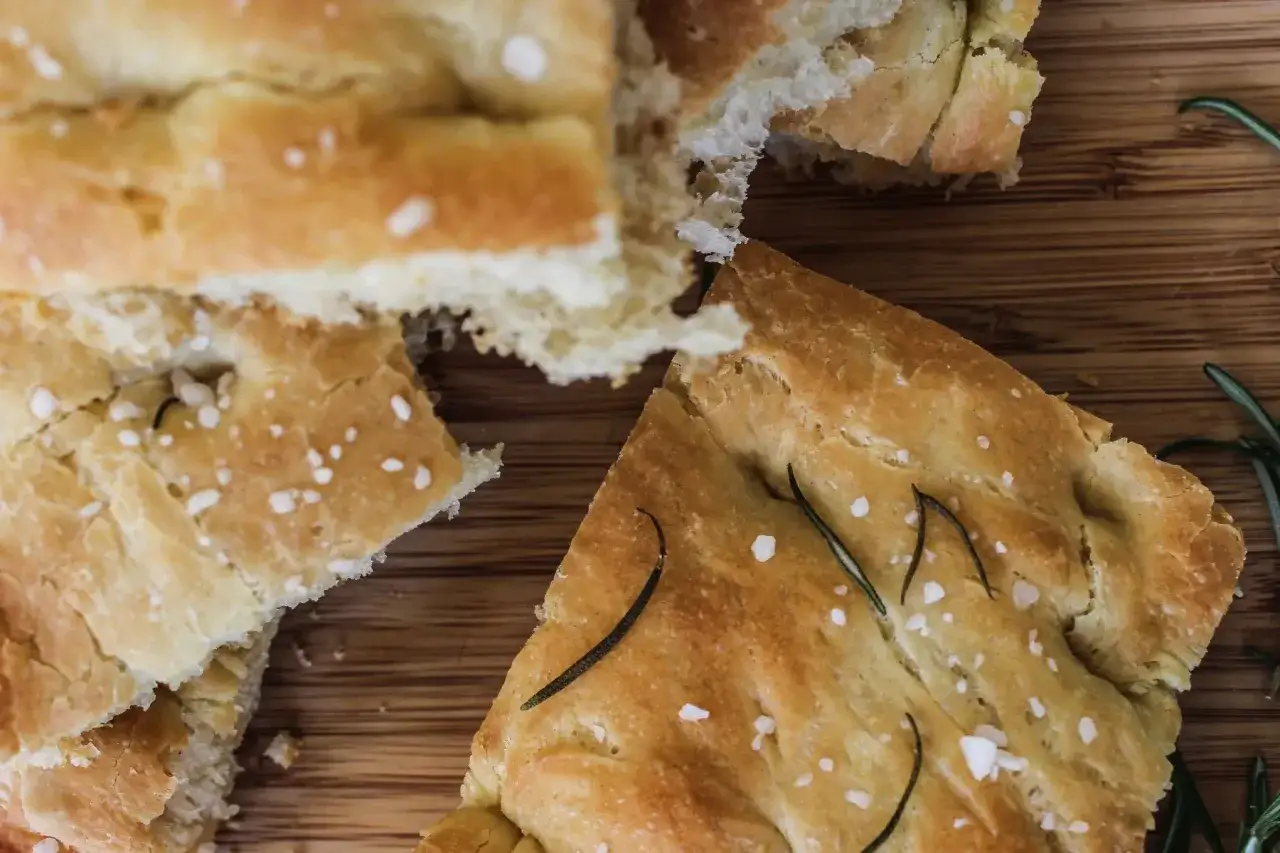 Chrupiąca schiacciata z rozmarynem i solą morską na drewnianej desce. Idealna na przekąskę.