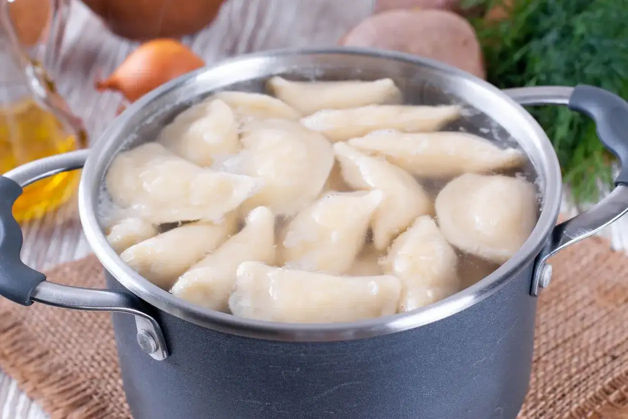 Pierogi gotują się w garnku. Dowiedz się, ile gotować pierogi, by były idealne.