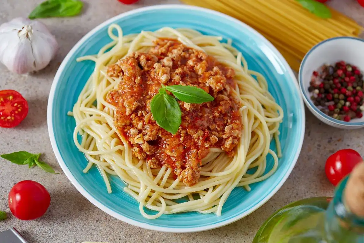 Pyszne spaghetti bolognese, prosty przepis na szybki obiad. Aromatyczny sos mięsny z pomidorami i bazylią na złocistym makaronie.