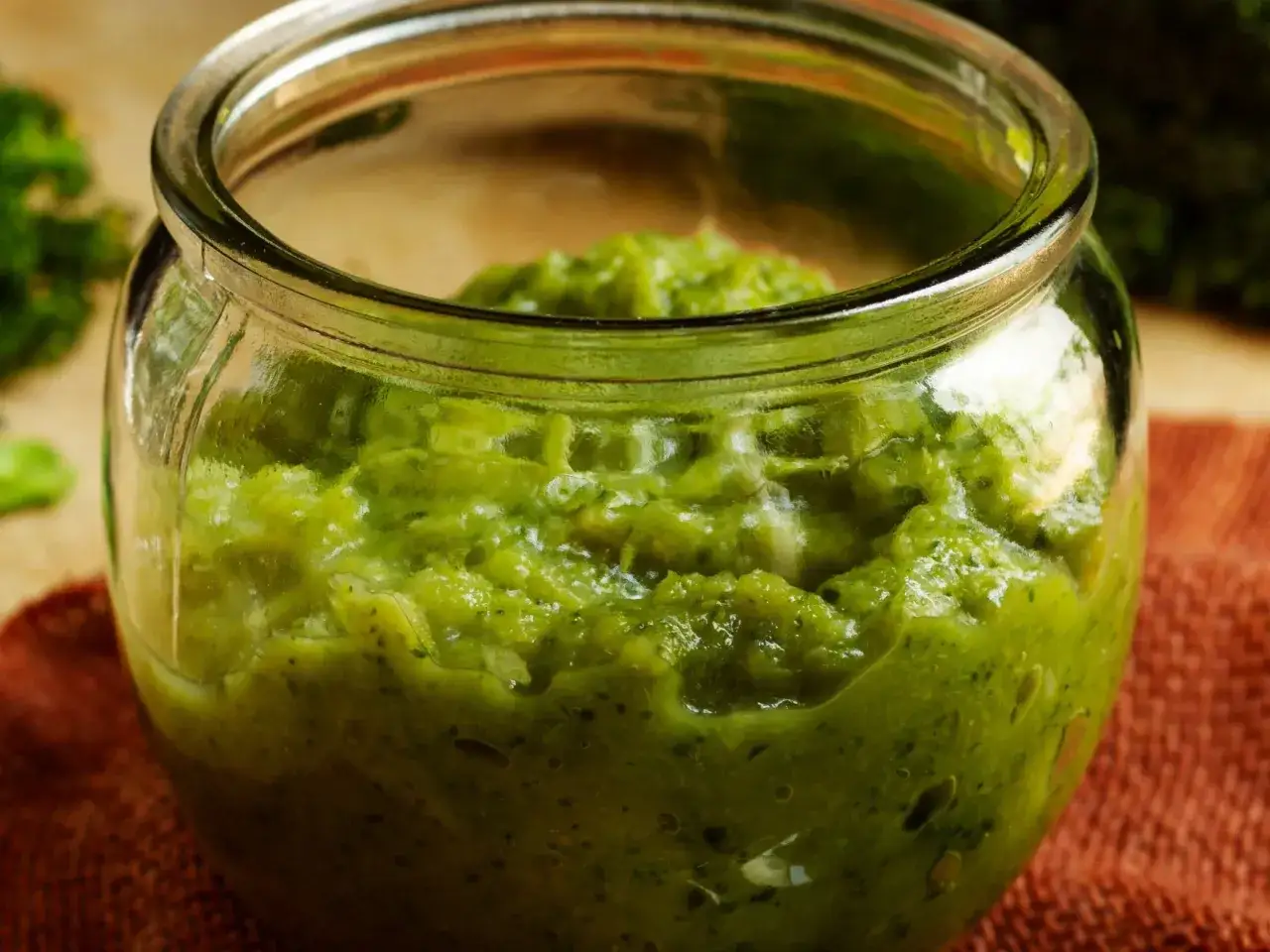 Słoik pełen domowego pesto z pietruszki, gotowego do dodania smaku do potraw.