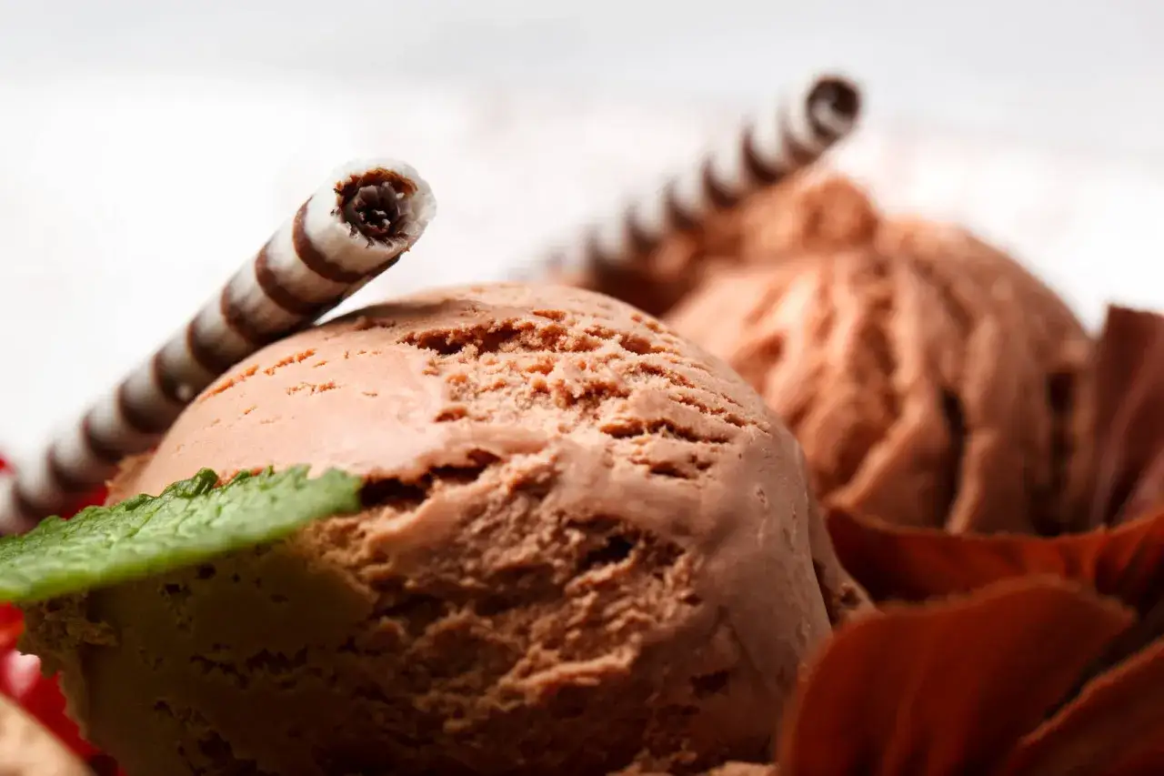 Czekoladowe lody domowe, udekorowane wafelkiem i listkiem mięty. Idealne na lato, gdy szukasz prostego przepisu na lody domowe.